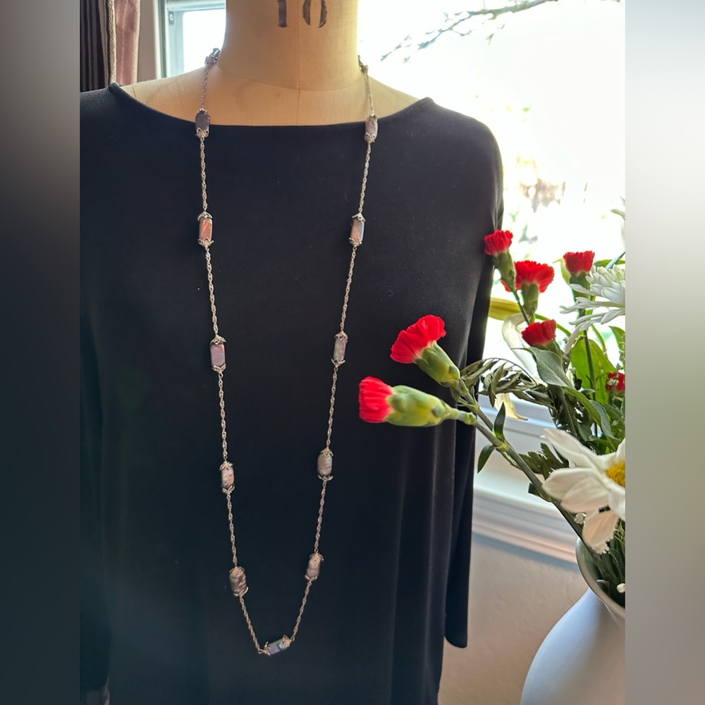 Unique drama with this silver and iridescent gray necklace .